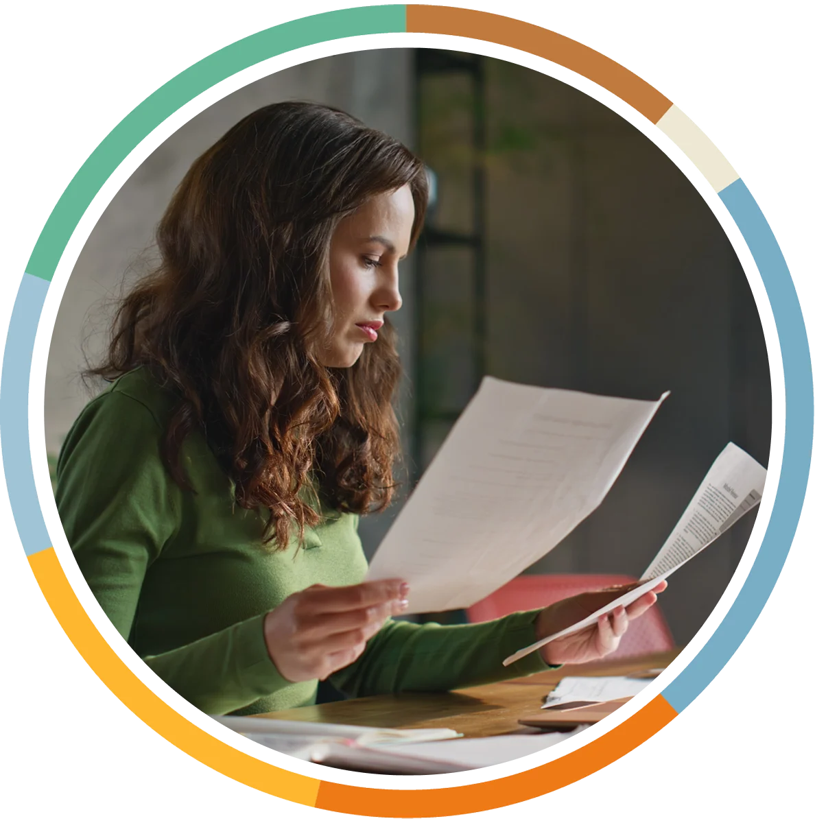 Woman looking at papers on her desk, focusing intently