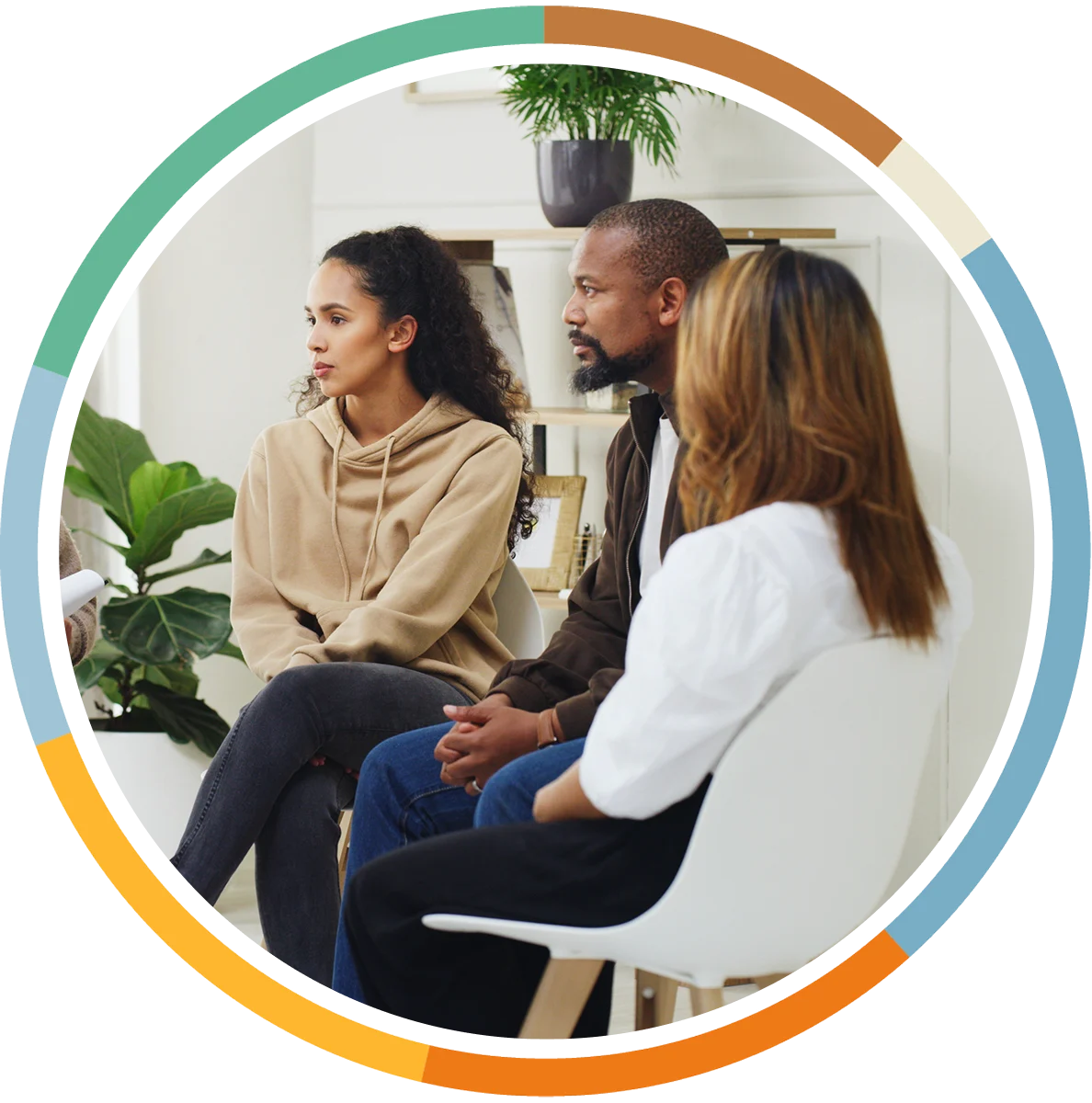 Young people sitting in semi-circle group discussion, focusing intently at subject off screen